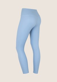 Leggings azzurri chiari con un tessuto liscio e elasticizzato. Vita alta, silhouette aderente e cuciture piatte per il comfort.