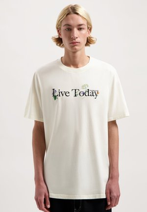Weißes Baumwoll-T-Shirt mit kurzen Ärmeln, versehen mit dem Aufdruck "Live Today" und floralem Design. Gerader Schnitt, einfacher Ausschnitt und Etikett-Detail.