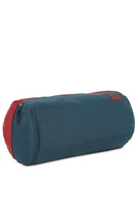 Bolsa de viaje rectangular de tela azul oscuro con acentos rojos. Presenta un zipper en un lado y un parche con el logo. Textura suave en toda la superficie.
