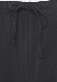Sorte sweatpants med elastisk talje og snøre. Glat tekstur, enkelt design og ingen synlige mønstre eller detaljer.