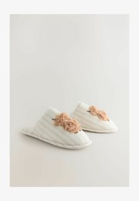 Zapatillas de tela con rayas en blanco y beige con un suave detalle de piel sintética rosa en la parte delantera. Diseño de punta redondeada con suela acolchada.