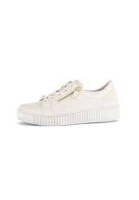 Crème-kleurige casual sneaker met een dikke ribbelzool, een zijrits en vetersluiting met gouden hardware, geïsoleerd op een witte achtergrond.