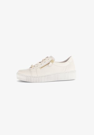 Crème-kleurige casual sneaker met een dikke ribbelzool, een zijrits en vetersluiting met gouden hardware, geïsoleerd op een witte achtergrond.