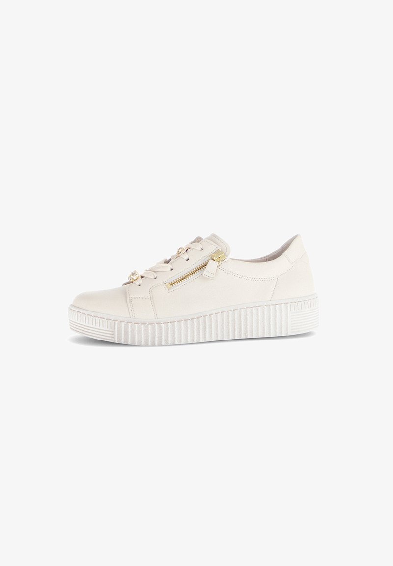 Cremefarbene lässige Sneaker mit dickem profiliertem Sohlen, seitlichem Reißverschluss und Schnürung mit goldfarbenen Akzenten, isoliert auf weißem Hintergrund.