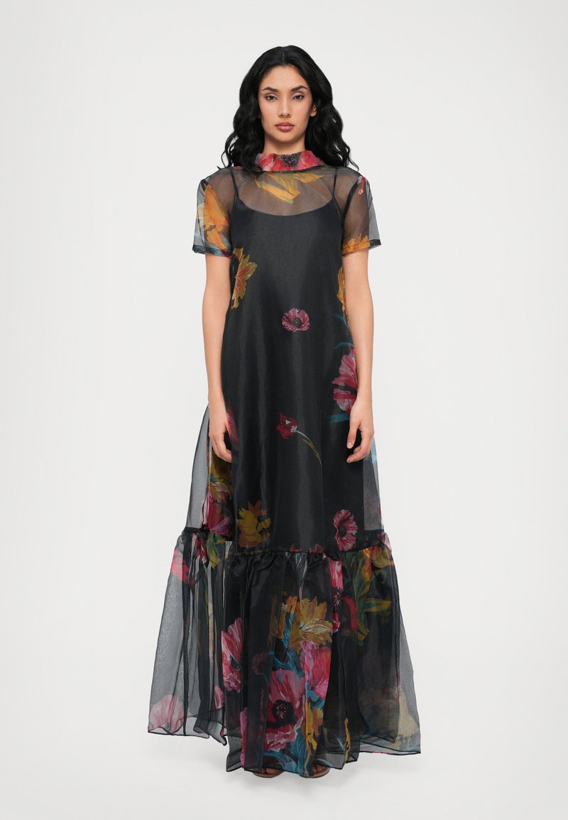 Vestido maxi negro con estampado floral y capa de tul, con mangas cortas, dobladillo con volantes y patrones de flores coloridas en rosa, amarillo y azul.
