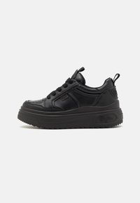 Sorte plattform sneakers med en teksturert læroverdel, rund tå, snøring foran og merkenavn på sidene og hælen.