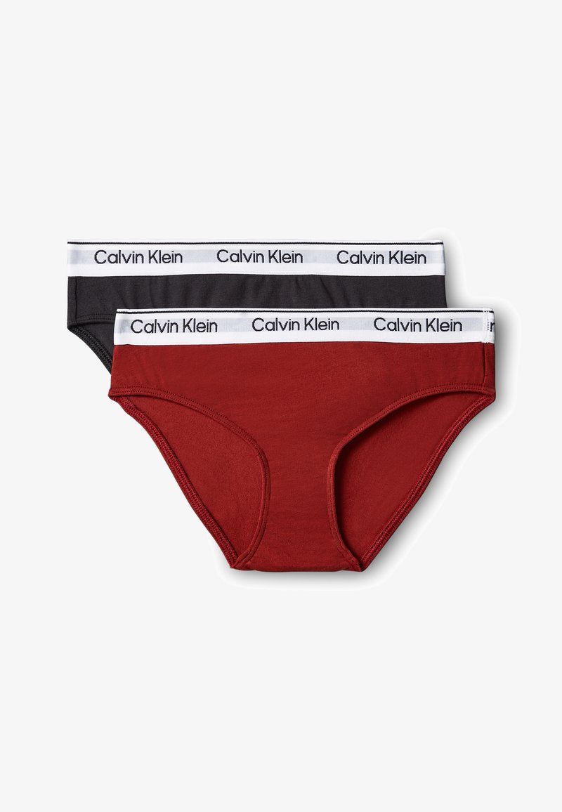 Deux paires de slips pour femmes Calvin Klein en noir et rouge foncé, chacun avec une ceinture blanche avec le logo Calvin Klein en noir.