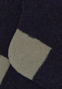 Calze blu navy e verde oliva con maglia testurizzata, corpo principale blu navy e sezioni di tallone e punta in verde oliva a contrasto.