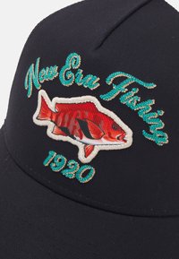 Marineblaues Cap mit gesticktem roten Fischdesign und dem Schriftzug "New Era Fishing" in Türkis und Gold, mit dem Jahr "1920" darunter.