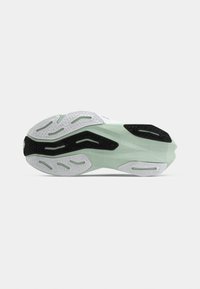 Green and black athletic shoe sole featuring textured grip patterns, a smooth curved shape, and a lightweight design with white accents.