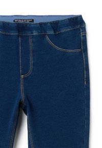 Leggings de denim azul con una textura suave, que presentan costuras en contraste, un bolsillo y una cintura elástica para mayor comodidad y ajuste.