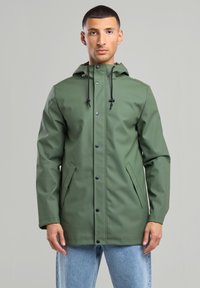 Olive green waterproof jacket with a front snap closure, adjustable hoodie, and side pockets, featuring a smooth, sleek texture.