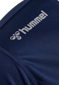 Marinblå atletisk tröja med texturerad tyg, har en framträdande grå "hummel"-logotyp och en slät halsringning.