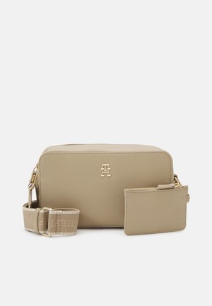 Sac bandoulière rectangulaire beige avec bandoulière en tissu détachable et petite pochette zippée attachée, accessoires dorés et logo embossé à l’avant.