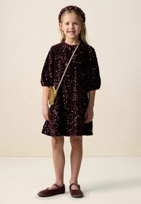 Weinrotes Pailletten-Kleid mit aufgepufften Ärmeln, Rundhalsausschnitt, kombiniert mit einer Tasche mit Goldmuster und passenden weinroten Schuhen. Haarreif inklusive.