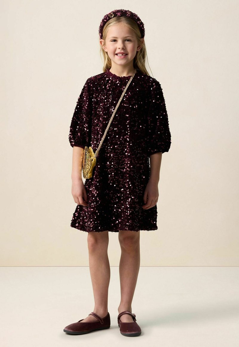 Weinrotes Pailletten-Kleid mit aufgepufften Ärmeln, Rundhalsausschnitt, kombiniert mit einer Tasche mit Goldmuster und passenden weinroten Schuhen. Haarreif inklusive.