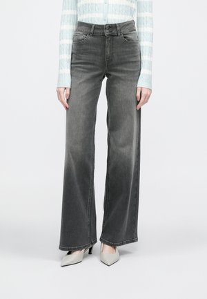 Jeans grigi a gamba larga con finitura sbiadita, chiusura con bottoni e design a cinque tasche. Abbinati a tacchi chiari con punta a punta.