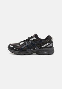 Schwarze Sportschuhe mit einem Obermaterial aus Mesh, synthetischen Überzügen, runden Schnürsenkeln, gepolsterten Sohlen und einer Gummisohle mit dem "GORE-TEX"-Label.