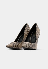 Escarpins à bout pointu avec un design texturé imprimé serpent dans des nuances de brun et beige, dotés d'un intérieur noir et d'une silhouette élégante.