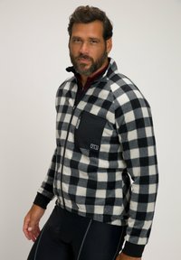 Schwarz-weiße karierte Fleecejacke mit Reißverschluss auf der Vorderseite, einer Brusttasche links und schwarzen Akzenten an den Bündchen und am Saum.