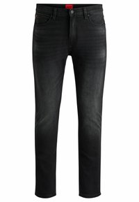 Black denim jeans with a slim fit, front pockets, and a button closure. Features subtle fading and a red logo tag at the waistband.