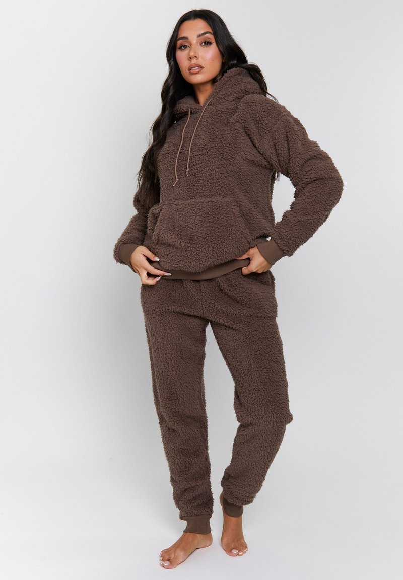 Brun fleece loungewear sæt med hættetrøje og joggerbukser. Struktureret stof, elastiske manchetter, frontlomme på trøjen, afslappet pasform.