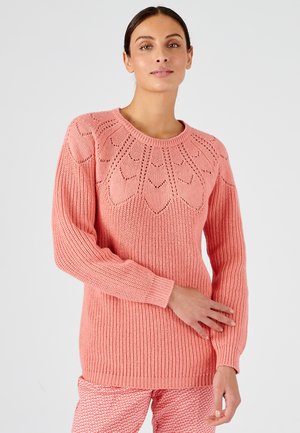 Pull en tricot rose présentant un design à côtes, un motif de yoke inspiré des fleurs et des manches longues. Texture lisse avec une coupe décontractée.