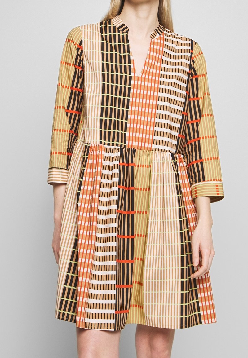 Kurzärmeliges Kleid mit V-Ausschnitt, aus gemustertem Stoff in Beige, Orange, Schwarz und Grün, mit gerafftem Taillenteil und abfallendem Saum.