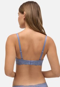 Sujetador de encaje azul claro con espalda de encaje, tirantes ajustables, tela texturizada y cierre de gancho y ojo. El borde de encaje se presenta a lo largo de la banda.