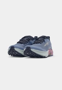 Trail running shoes in navy blue and light gray; textured rubber sole with prominent lugs, pink accent on the heel, and lace-up design.