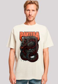 Cremfarbener T-Shirt mit einem detaillierten schwarzen und roten Schlangendesign und dem Wort "PANTERA" in fettem, abgenutztem Schriftzug.