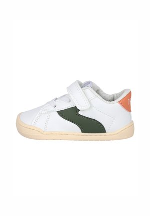 Zapatilla deportiva blanca para niño pequeño con tira verde lateral, suela beige, lengüeta naranja en el talón, cordones y cierre de velcro.