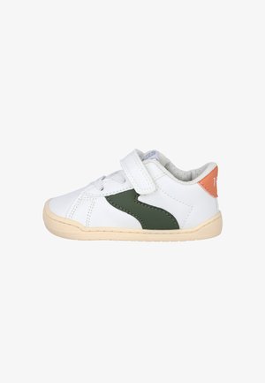 Zapatilla deportiva blanca para niño pequeño con tira verde lateral, suela beige, lengüeta naranja en el talón, cordones y cierre de velcro.