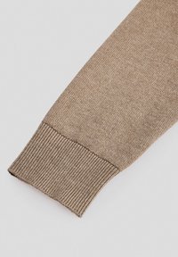 Brązowy dziany sweter z rękawem o ściągaczu. Gładka faktura z subtelnymi wariacjami kolorystycznymi. Brak widocznych wzorów lub dodatkowych elementów.