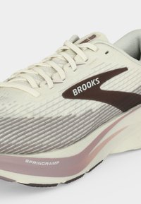 Light beige running shoe with brown Brooks logo, cream laces, and pink and white midsole labeled SpringRamp.