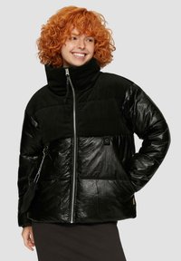 Zwarte pufferjack met hoge kraag; heeft een mix van glanzend en textuurmateriaal, ritsopening en zijvakken.