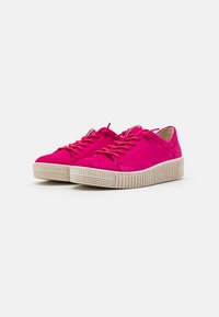 Rosa Wildledersneaker mit runder Zehenpartie, flacher beiger Gummisohle und passenden rosa Schnürsenkeln. Hat ein einfaches Design und eine weiche Textur.
