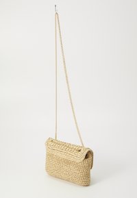 Geweven strooien schoudertas met een omgevouwen flap, gouden kettinghengsel en een gestructureerd oppervlak; natuurlijke beige kleur.