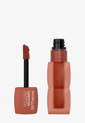 Il rossetto liquido Maybelline Super Stay Teddy Tint in un applicatore quadrato presenta una punta morbida e soffice per un'applicazione precisa. Colore: marrone caldo.