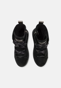 Scarpe alte in suede nero con superficie testurizzata, lacci piatti neri e dettaglio con cerniera. Presentano un interno imbottito e suola in gomma.