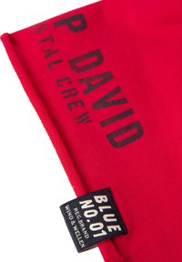 Red fabric with black text "P DAVID Stal Crew" and a black label reading "BLUE NO. 01 Reg. Brand Wind & Wellen" stitched on the corner.
