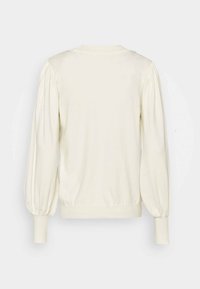 Pull à manches longues couleur crème avec épaules bouffantes et poignets et ourlet côtelés, vu de dos sur un fond uni.