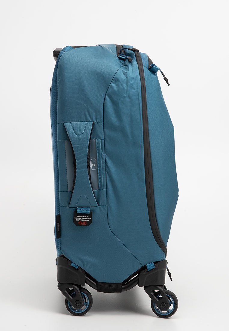 Blauer Koffer mit Rädern, der über eine strukturierte Außenseite, einen robusten Griff und einen Reißverschlussverschluss verfügt. Enthält ein Markenetikett und langlebige Kunststoffräder.