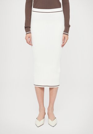 Falda de punto acanalado blanca con una silueta entallada, con un ribete marrón a contraste en la cintura y el dobladillo. Textura suave, largo por debajo de la rodilla.