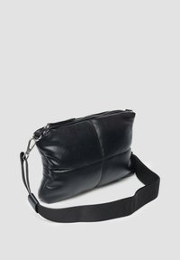 Schwarze Lederhandtasche mit weicher Textur, rechteckiger Form und Reißverschluss. Verfügt über einen abnehmbaren Schulterriemen und genähte Paneeldetails.