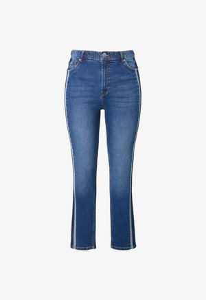 Vaqueros de mezclilla de cintura alta, pierna acampanada y rayas laterales en contraste. La tela es de un azul medio con una textura suave y un desvanecimiento mínimo.