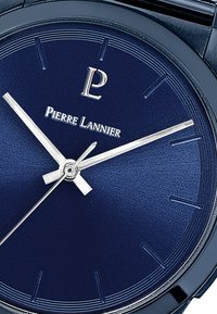 Plavi sat s neobično finou površinom, srebrne kazaljke, oznakom "Pierre Lannier" i minimalističkim oznakama sati.