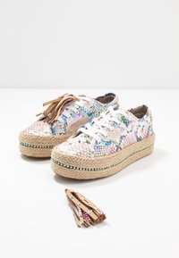Paire de baskets à plateforme avec motif serpent multicolore et lacets blancs, avec des breloques pampilles amovibles en cuir tan ornées de clous colorés.