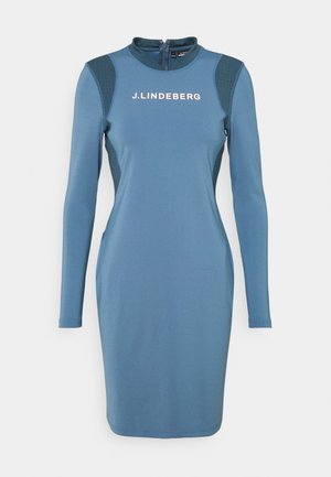 Sininen pitkähihaiset vartalonmyötäiset mekko, jossa J.LINDEBERG-logo rinnassa, pehmustetut olkapäät ja vetoketjusuljenta takana.