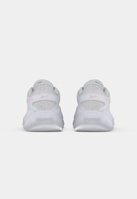 Baskets blanches avec une tige en mesh, accents rose pastel et col rembourré. Caractérisées par une semelle épaisse et texturée, avec un logo "Reebok" en relief.